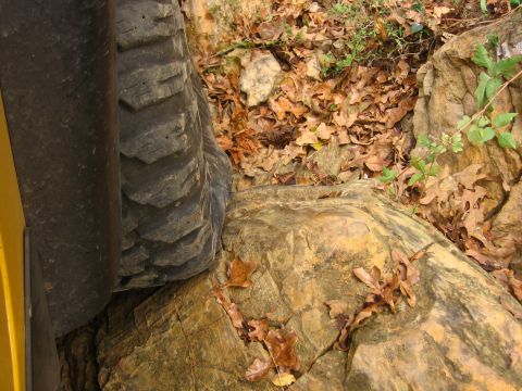 2001 Jeep Wrangler - An off-road tire navigates a challenging rocky terrain during an outdoor excursion.