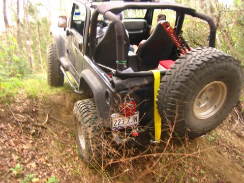 2001 Jeep Wrangler - A 2001 Jeep Wrangler navigates a wooded trail with its rear facing the camera.