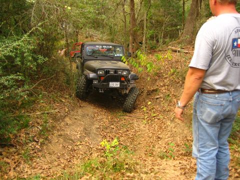 2001 Jeep Wrangler - Two Jeeps navigate a wooded trail with a person observing the action.