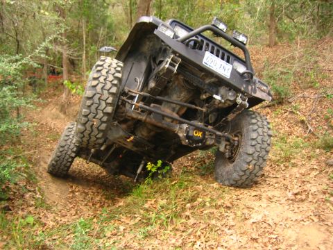 2001 Jeep Wrangler - This Jeep Wrangler is on an off-road trail, with one side significantly higher than the other.