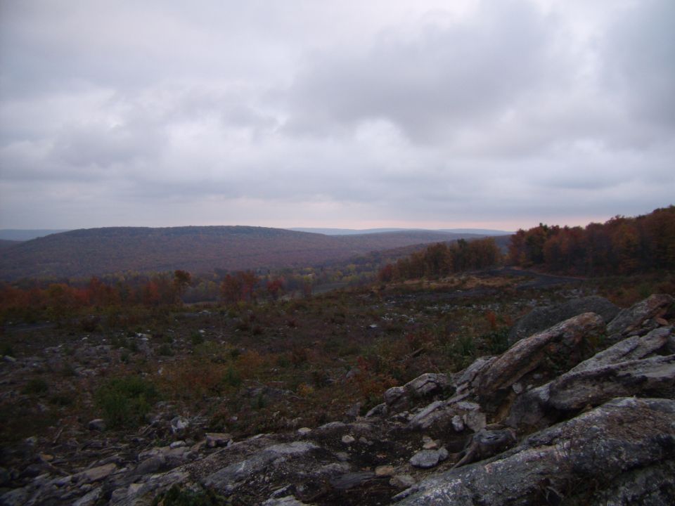 Rocky terrain with distant hills under a cloudy sky