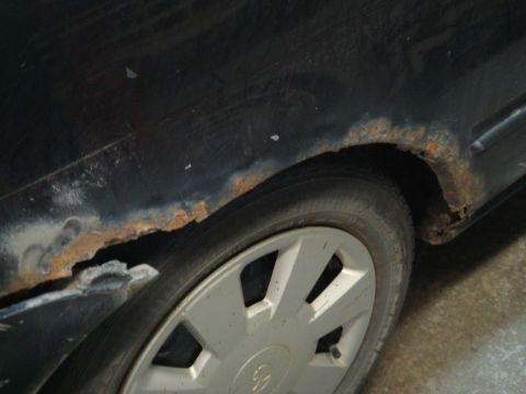 1996 Ford Bronco - Rust is visible along the edge of the rear wheel well of a black vehicle.