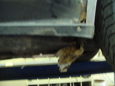 1996 Ford Bronco - Severe rust damage is visible on the lower body panel of the vehicle.