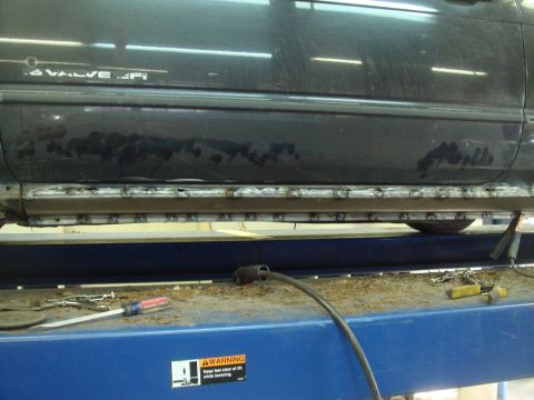 1996 Ford Bronco - A vehicle's rocker panel is shown undergoing welding repairs due to rust damage.