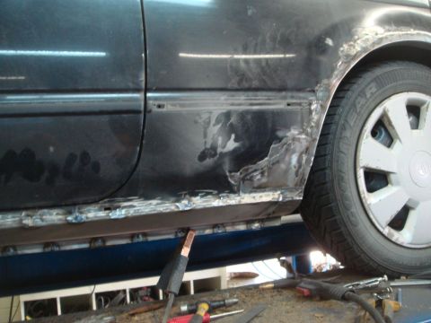 1996 Ford Bronco - Bodywork in progress on a vehicle's lower side panel, showing welding and repair.