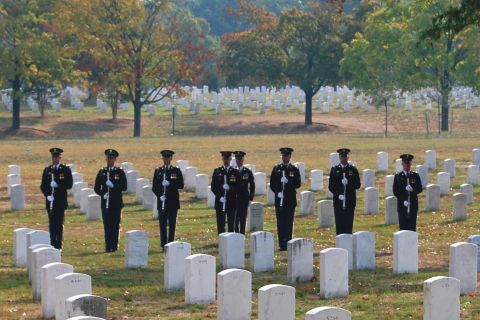 1991 Ford Bronco - A group of soldiers stand at attention in a cemetery, likely a memorial service.