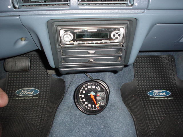 Ford truck center console with aftermarket stereo and floor-mounted gauge