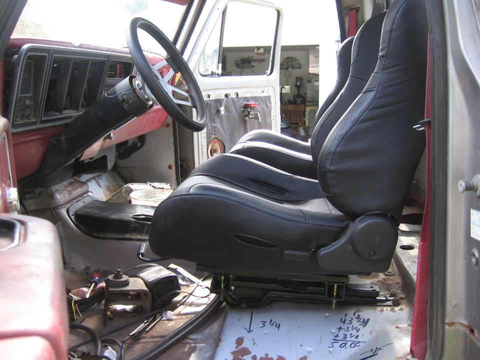 Black aftermarket bucket seat installed in a stripped truck interior cab