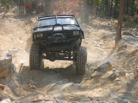 1992 Ford Mustang - An off-road vehicle tackles a challenging dirt path with another vehicle visible in the background.