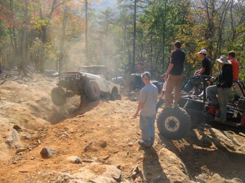 1992 Ford Mustang - Off-road enthusiasts navigate a challenging dirt trail during an autumn day.