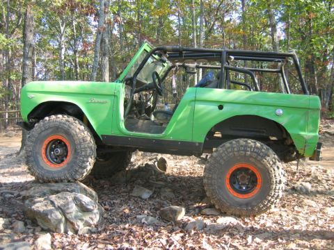 1992 Ford Mustang - Modified green Ford Bronco with off-road tires navigating rocky terrain.