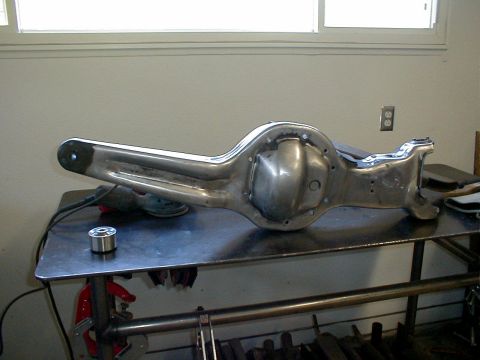 1996 Ford Bronco - A polished rear axle housing sits on a metal table, ready for installation or further work.