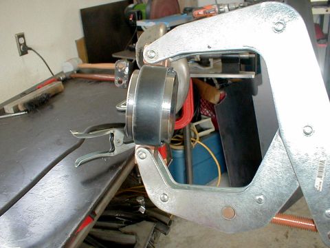 1996 Ford Bronco - Metal part secured with clamps on a workbench, likely for repair or fabrication.