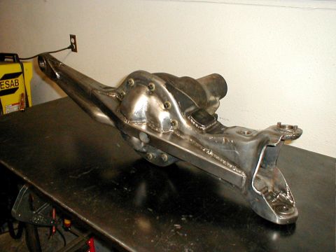 1996 Ford Bronco - A custom-modified front axle differential housing sits on a workbench, likely awaiting installation.