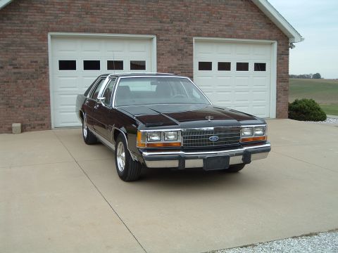 1989 Ford Crown Victoria LTD - This 1989 Ford Crown Victoria LTD is seen in a 3/4 front view parked in front of a garage.