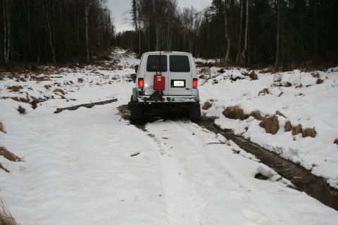 2003 Jeep TJ - A white van navigates a challenging snowy and muddy terrain.