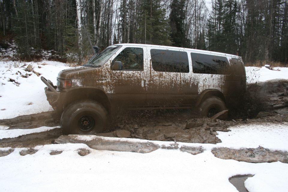 White van driving through mud and snow, with snorkel