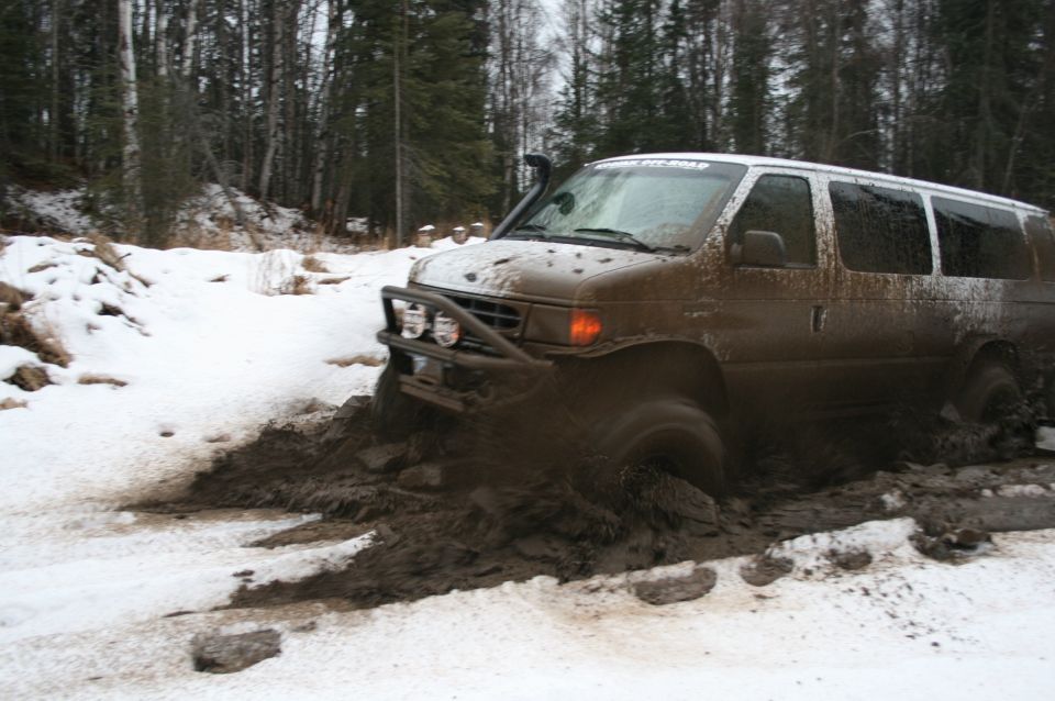 Muddy van stuck in snow and mud with snorkel and brush guard