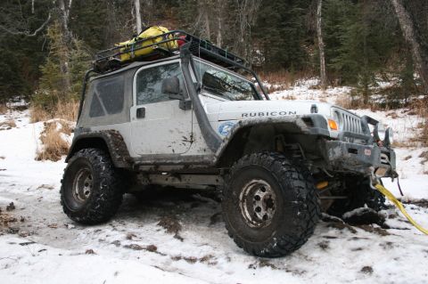 2003 Jeep TJ - White 2003 Jeep TJ Rubicon equipped for off-roading, stuck in a snowy environment.