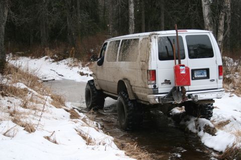 2003 Jeep TJ - Modified van navigates a challenging snowy and wet terrain with off-road tires and auxiliary fuel.