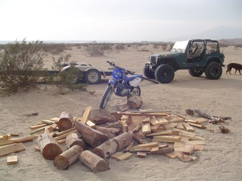 2000 Jeep TJ - A green 2000 Jeep TJ is parked in a desert landscape next to a motorcycle and a trailer.