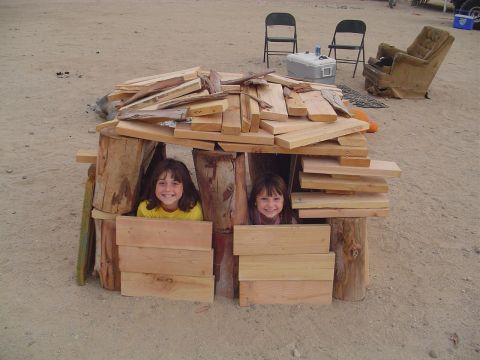 2000 Jeep TJ - Two children are playing inside a fort made of wood scraps and logs.