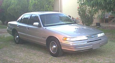 1994 Ford Crown Victoria - This 1994 Ford Crown Victoria is seen from a 3/4 front angle, parked outdoors on a grassy area.