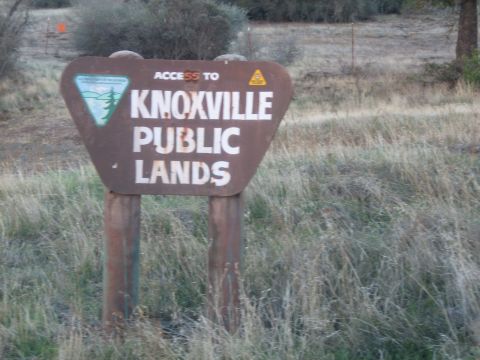 1995 Ford Bronco - A sign indicates access to Knoxville Public Lands, surrounded by dry grass and brush.