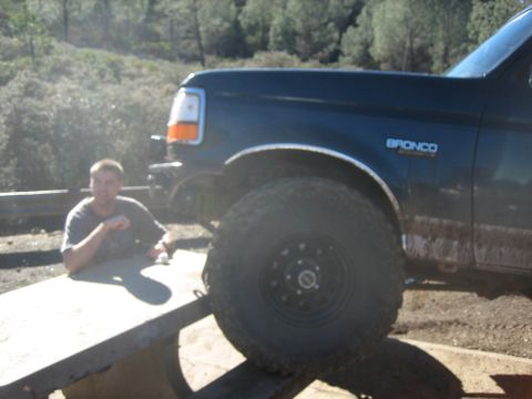 1995 Ford Bronco - A dark blue 1995 Ford Bronco is seen loaded onto a trailer, with a man leaning on the trailer bed.