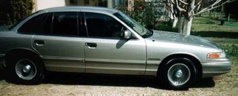 1994 Ford Crown Victoria - Side profile of a silver 1994 Ford Crown Victoria sedan parked outdoors.