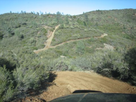 1995 Ford Bronco - Off-road trail on a hillside with a view of the landscape.