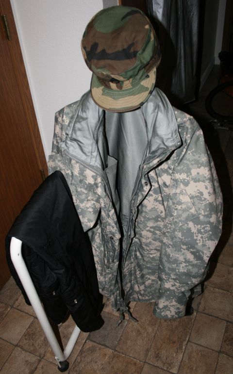 2003 Jeep TJ - A military uniform, including a jacket and pants, is displayed on a rack with a camouflage hat.
