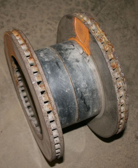 2003 Jeep TJ - This image shows a rusted brake rotor assembly, likely a component from a vehicle, with a black central hub.