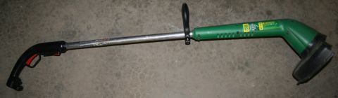 2003 Jeep TJ - A green electric string trimmer is shown against a concrete background.