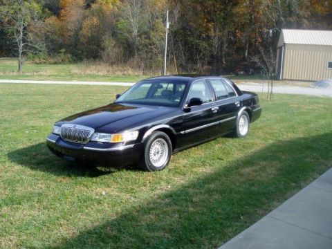 2001 Mercury Grand Marquis - A black 2001 Mercury Grand Marquis is parked on the grass next to a shed.