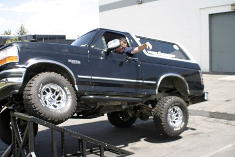 1994 Ford Bronco - A black Ford Bronco is shown with its driver's side facing the camera, positioned on ramps.