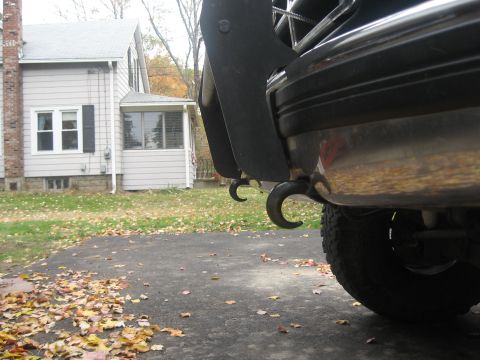 1996 Ford Bronco - Close-up view of the rear tow hooks on a vehicle, with a residential house in the background.