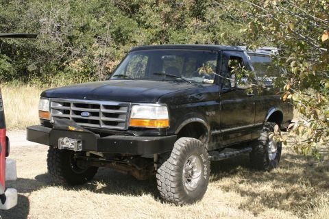 1994 Ford Bronco - This 1994 Ford Bronco features a custom front bumper with a winch, large off-road tires, and a lifted suspension.
