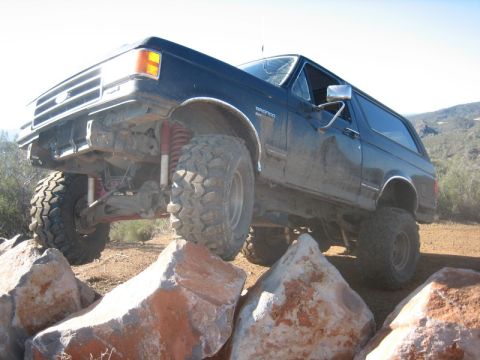 1989 Ford Bronco - This lifted Ford Bronco navigates a rocky obstacle course on a sunny day.