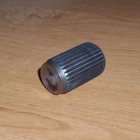 1981 Ford F-150 - A close-up view of a metal splined shaft, likely a vehicle component, on a wooden background.