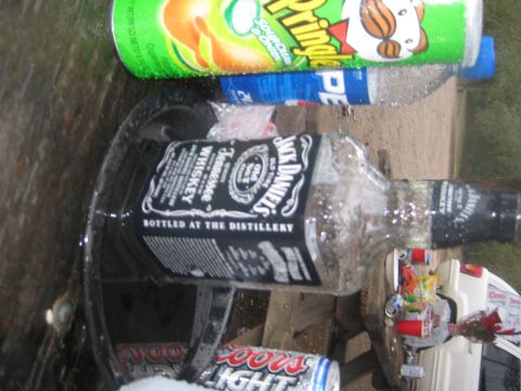 1966 Jeep CJ5 - A collection of beverages and a white vehicle component are visible in this outdoor scene.