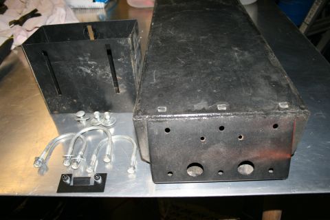 2003 Jeep TJ - Two metal containers and hardware are laid out on a metallic surface.
