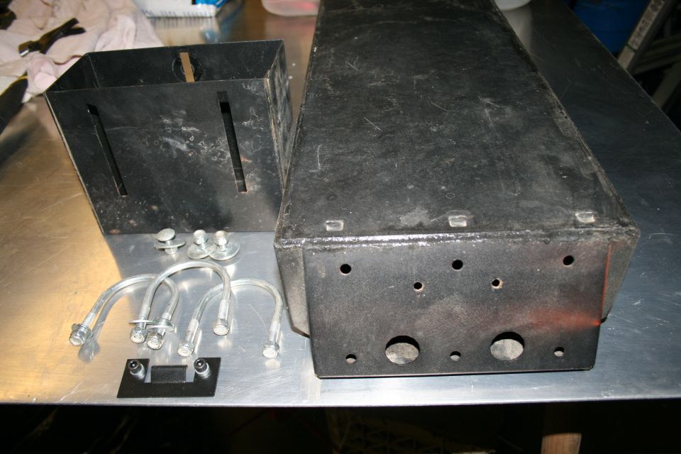 Two black metal boxes, one square and one rectangular, with assorted hardware including U-bolts and screws