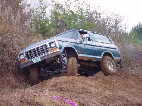 1979 Ford Bronco - This modified Ford Bronco is tackling a steep incline on a dirt trail.