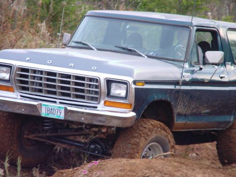 1979 Ford Bronco - This 1979 Ford Bronco is shown in a three-quarter front view, navigating off-road terrain.