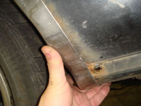 1996 Ford Bronco - Close-up of a vehicle's body panel showing rust and damage near the wheel well.