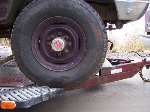 1996 Ford Bronco - A close-up view of a vehicle's wheel and trailer hitch assembly.