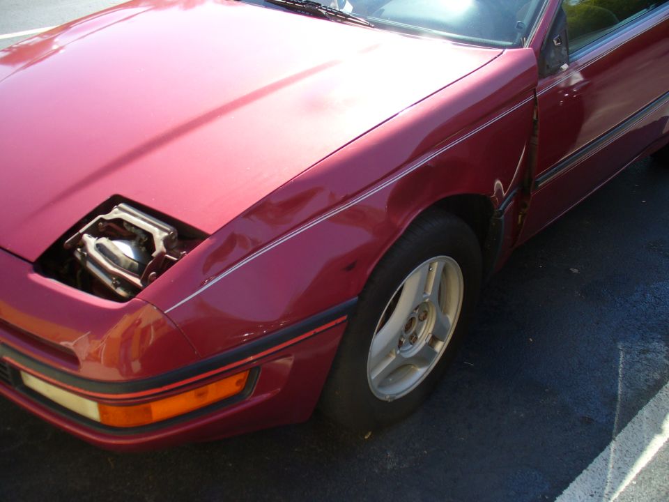Red 1991 Ford Probe front fender with pop-up headlight housing open