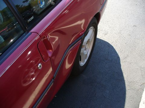 1991 Ford Probe - This red car has significant damage to its rear fender and door, with the word PROBE visible on the window.