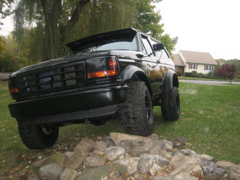 1995 Ford Bronco - This 1995 Ford Bronco is positioned on rocks, showing off its lifted suspension and off-road tires.